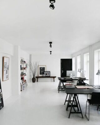 Progettazione d'interni ufficio con tavoli e sedie moderne di colore nero e pareti bianche