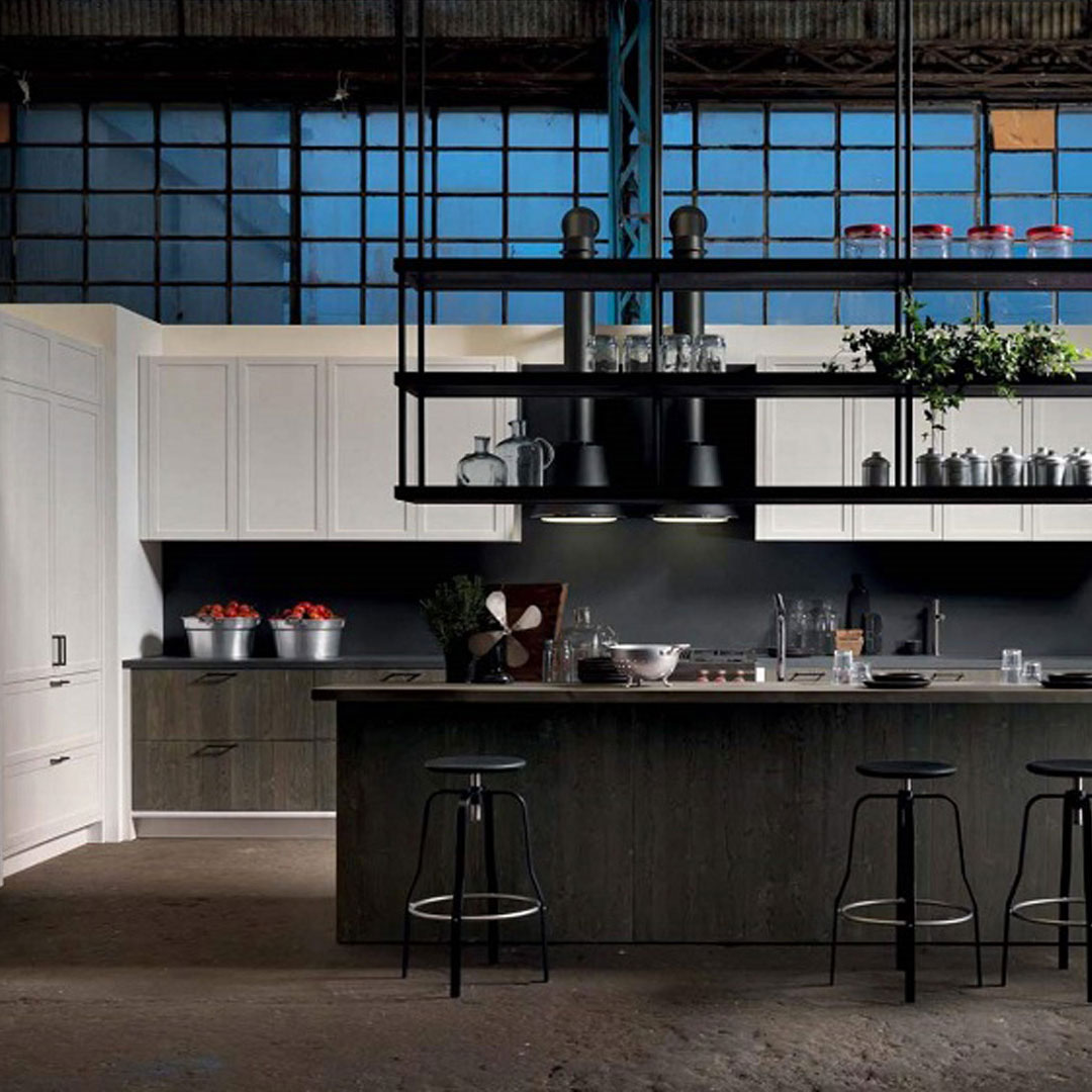 Una cucina moderna e elegante con mobili bianchi e scuri. Un grande isola centrale con sgabelli neri, illuminazione sobria e piante decorative.