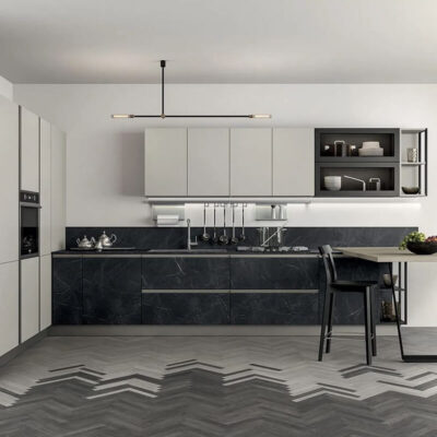 Cucina moderna con armadi bianchi e dettagli neri, piano in resina grigia e pavimento a zigzag. Tavolo da pranzo minimalista.