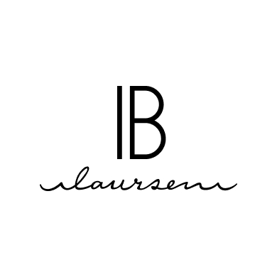Logo elegante di IB Laursen, composto da lettere stilizzate 'IB' sopra a una scritta in corsivo 'laursen', su sfondo bianco.