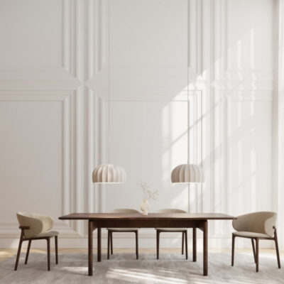 Un elegante ambiente interno con un tavolo in legno scuro, due lampade sospese e sedie moderne. Le pareti bianche presentano dettagli architettonici raffinati che creano un'atmosfera minimalista e luminosa.