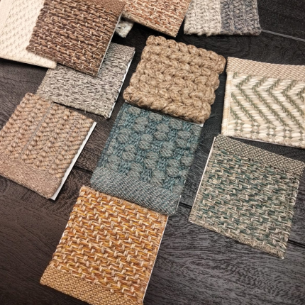 Campioni di tessuti e materiali per tappeti in diverse trame e colori, tra cui beige, blu e marrone. Visualizzazione di stili per arredamento.
