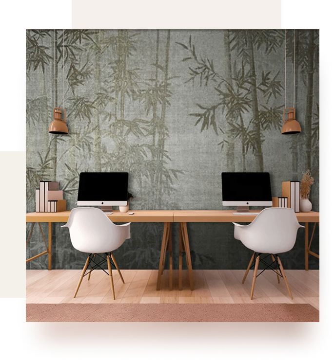 Due scrivanie moderne con computer su un murale di bamboo verde, creando un ambiente di lavoro rilassante ed elegante.